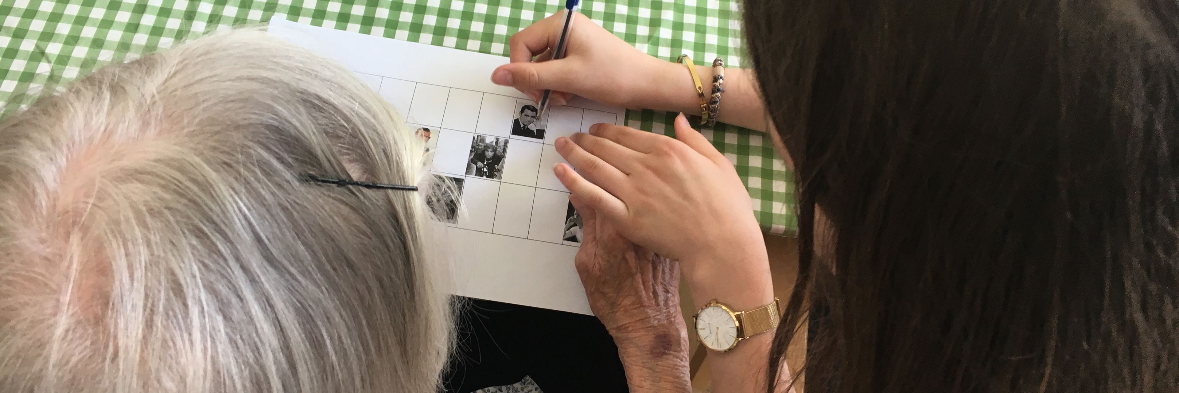 En medarbejder hjælper en beboer med at spille banko.